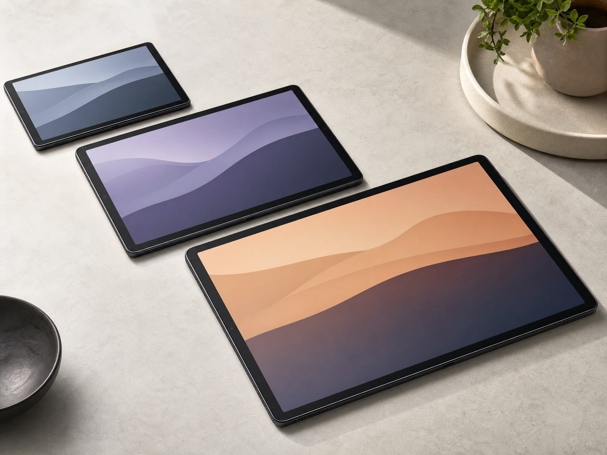 Three black Android tablets arranged from smaller to larger with the largest tablet in the foreground